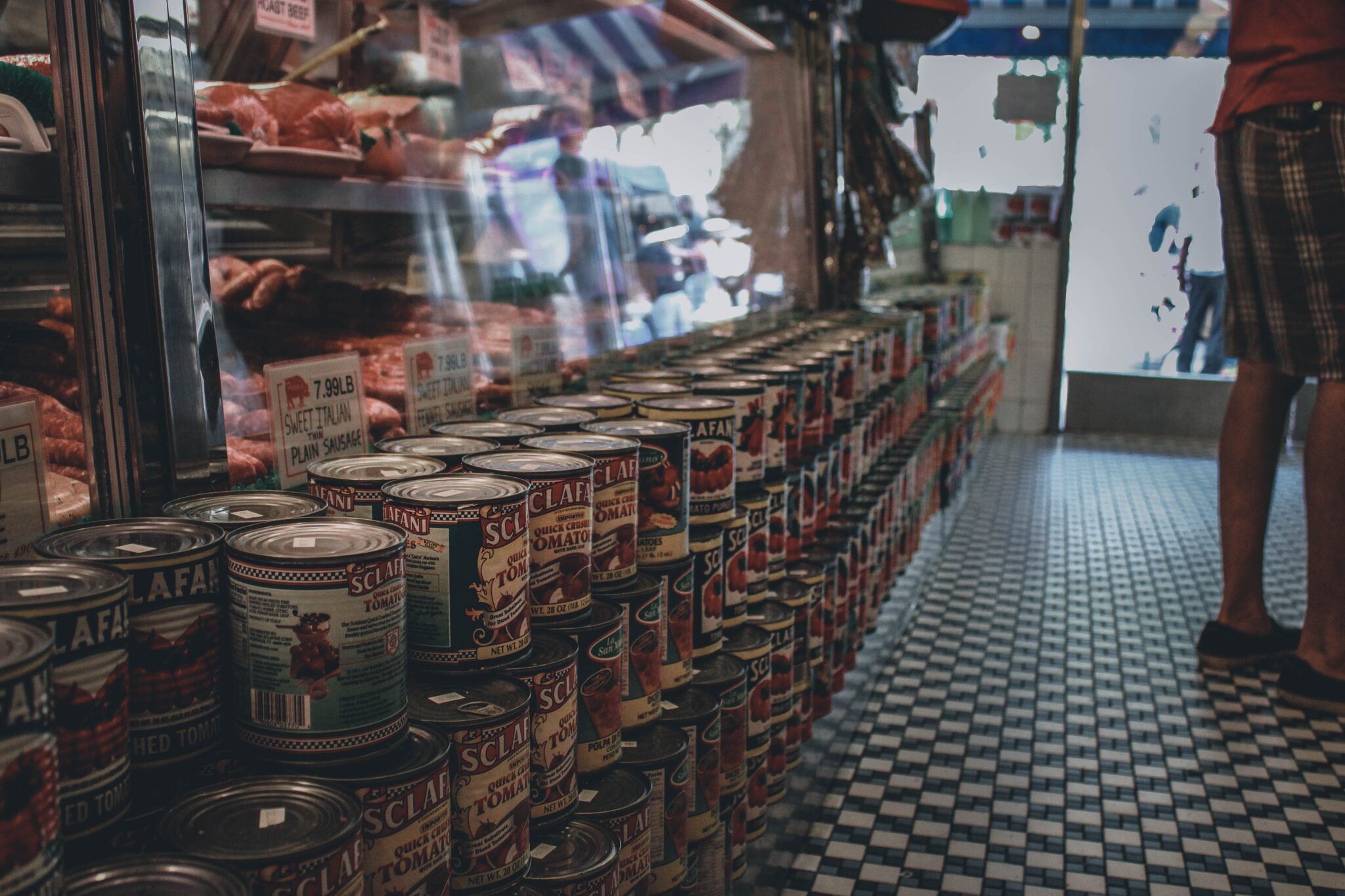 cheap foods that last a long time A row of canned goods lined on the floor inside the convenience store.