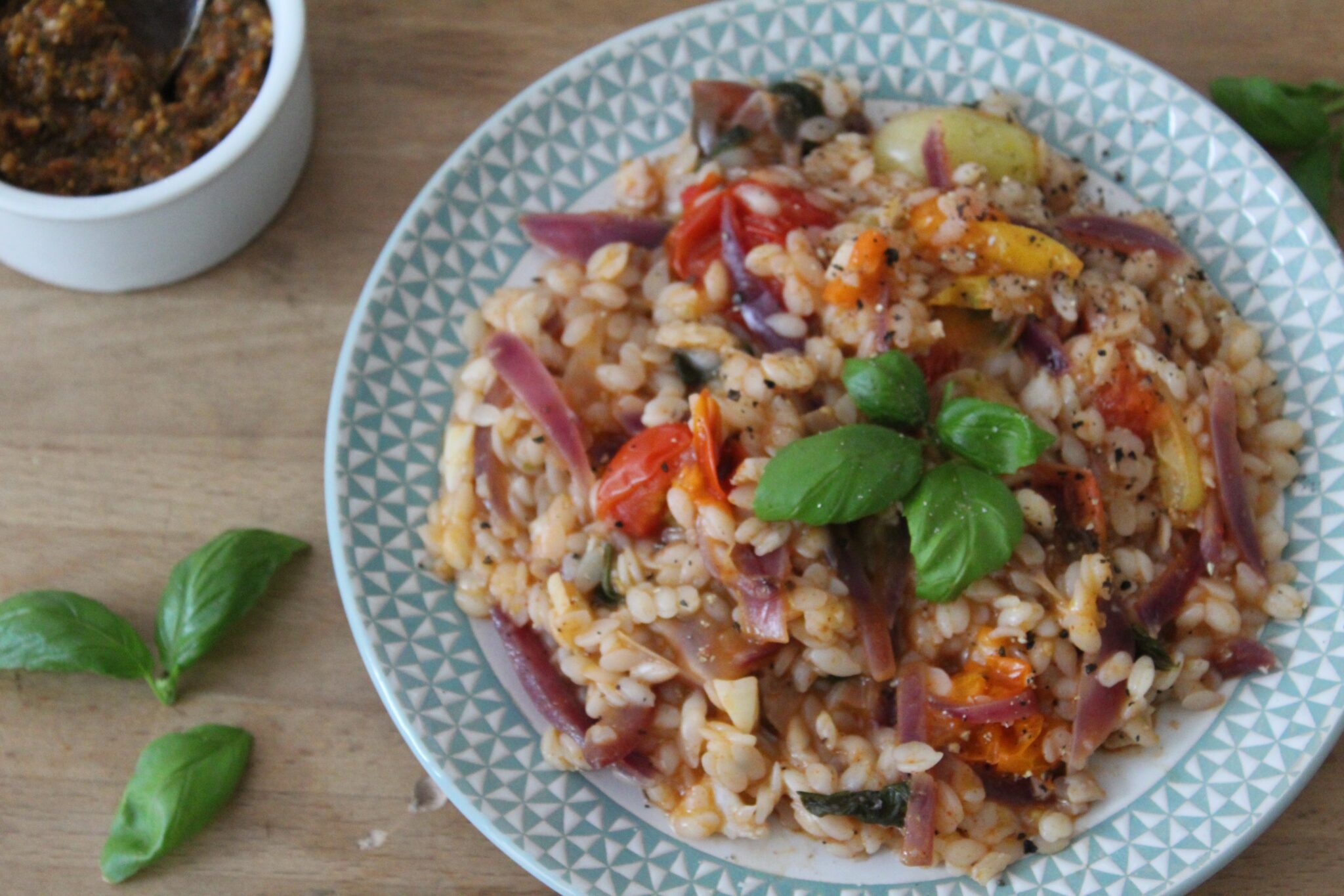 cheap foods that last a long time A bowl of rice and beans mixed with onion, tomato, garlic, and a herb on top.